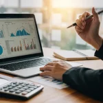 Pessoa analisando finanças no computador, calculadora e documentos sobre refinanciamento.